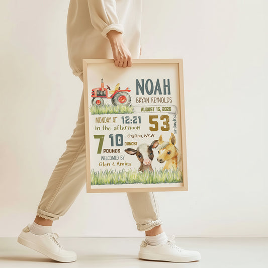 Person holding a framed birth announcement with farm animals and text.